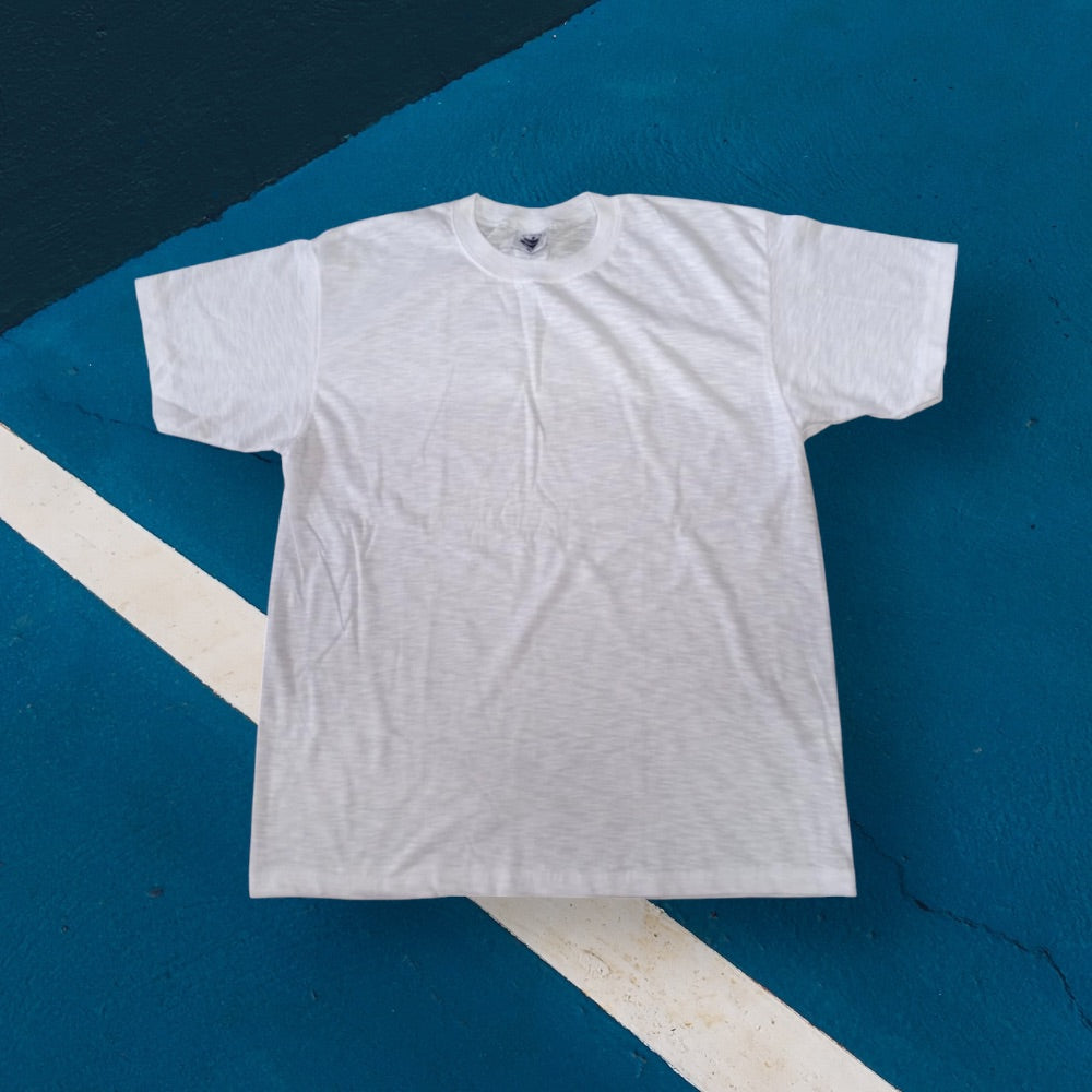 White linen cotton T-shirt laid flat on a blue and white geometric background